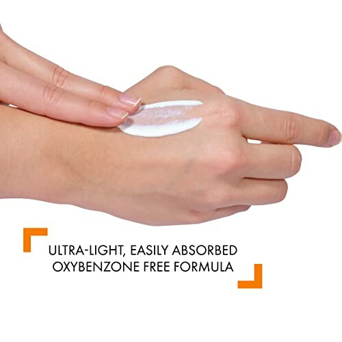 Person applying ultra-light, oxybenzone-free sunscreen on hand.